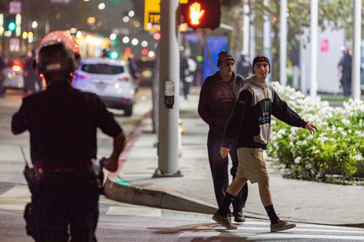 Men taunt a Los Angeles Police Department officer with profanity in Los Angeles on Nov. 6, 2020. (John Fredricks/The Epoch Times)