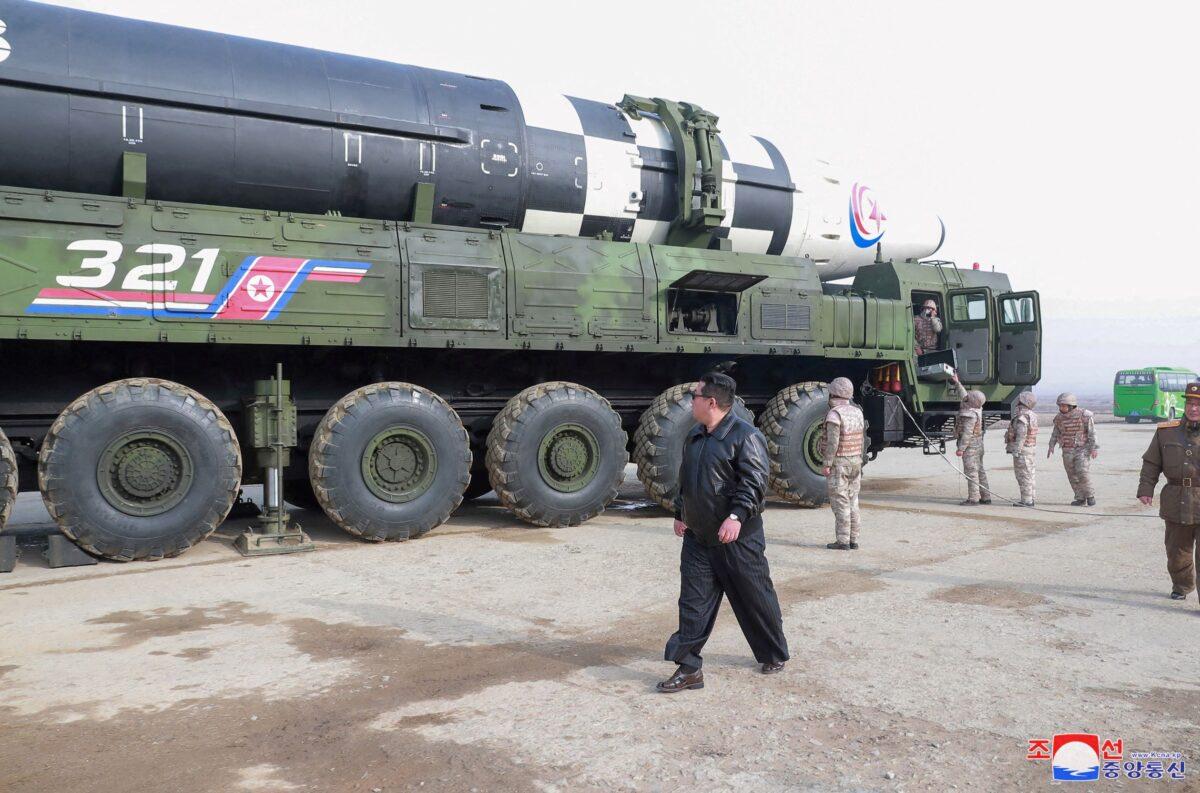 North Korean leader Kim Jong Un walks next to what state media reports is the "Hwasong-17" intercontinental ballistic missile on its launch vehicle in an undated photo released on March 25, 2022. (KCNA via Reuters)