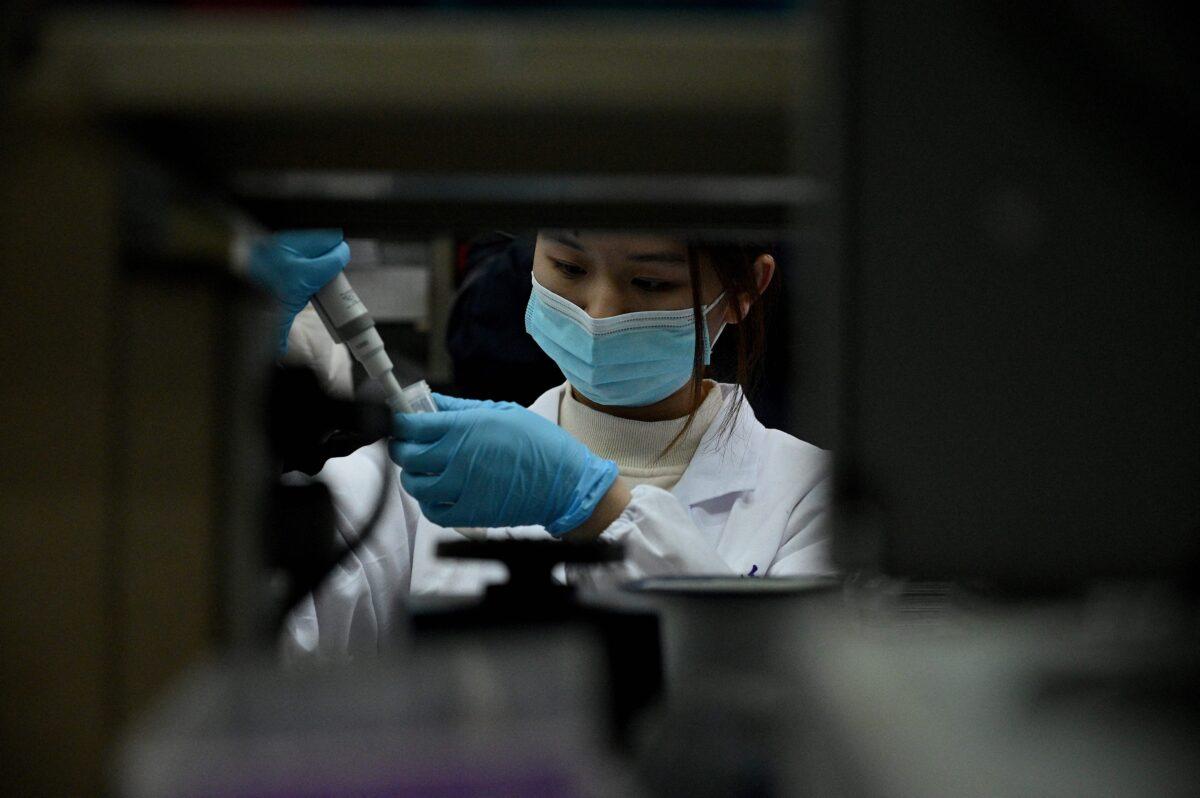 A laboratory technician works at a Tsinghua University lab in Beijing on Dec. 9, 2021. (Noel Celis/AFP via Getty Images)