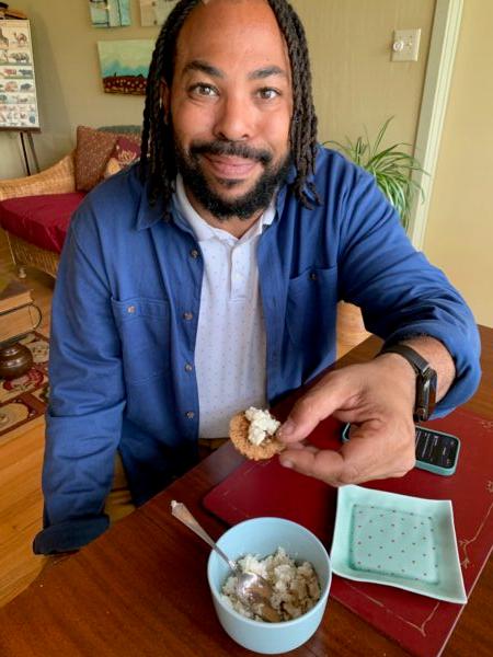 Seneca Scott samples cheese made from his goats’ milk on May 22, 2022. (Courtesy of Loretta Breuning)