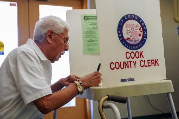 A voter fills out his ballot in Palos Hills, Ill., on June 28, 2022. (Cara Ding/The Epoch Times)