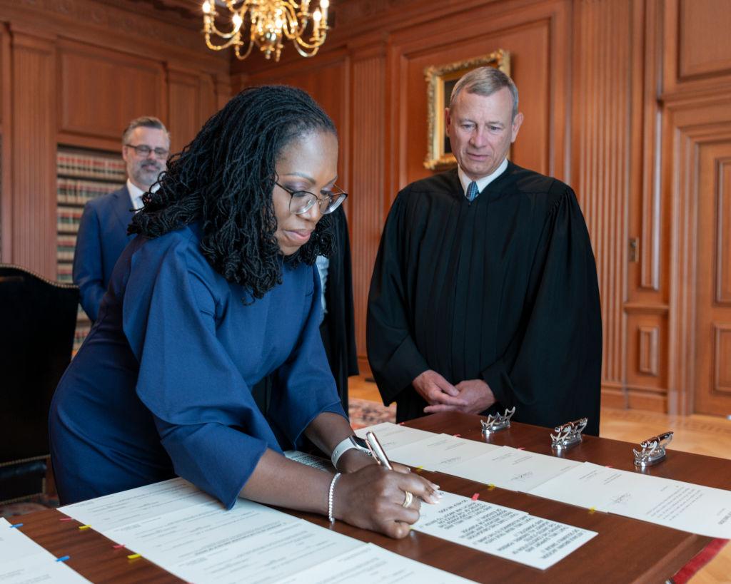 In this handout provided by the Supreme Court, Chief Justice John G. Roberts, Jr. (R) looks on as Justice Ketanji Brown Jackson signs the Oaths of Office in the Justices' Conference Room at the Supreme Court in Washington on June 30, 2022. (Fred Schilling/Collection of the Supreme Court of the United States)