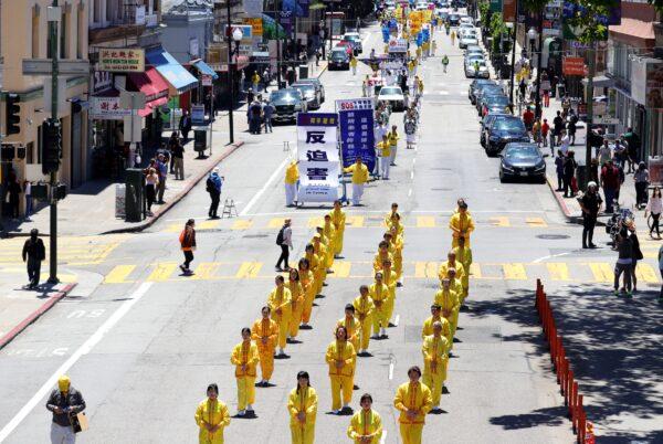 Practitioners demonstrate one of the Falun Gong exercises in a parade passing through Chinatown in San Francisco on July 16, 2022. (Cynthia Cai/The Epoch Times)