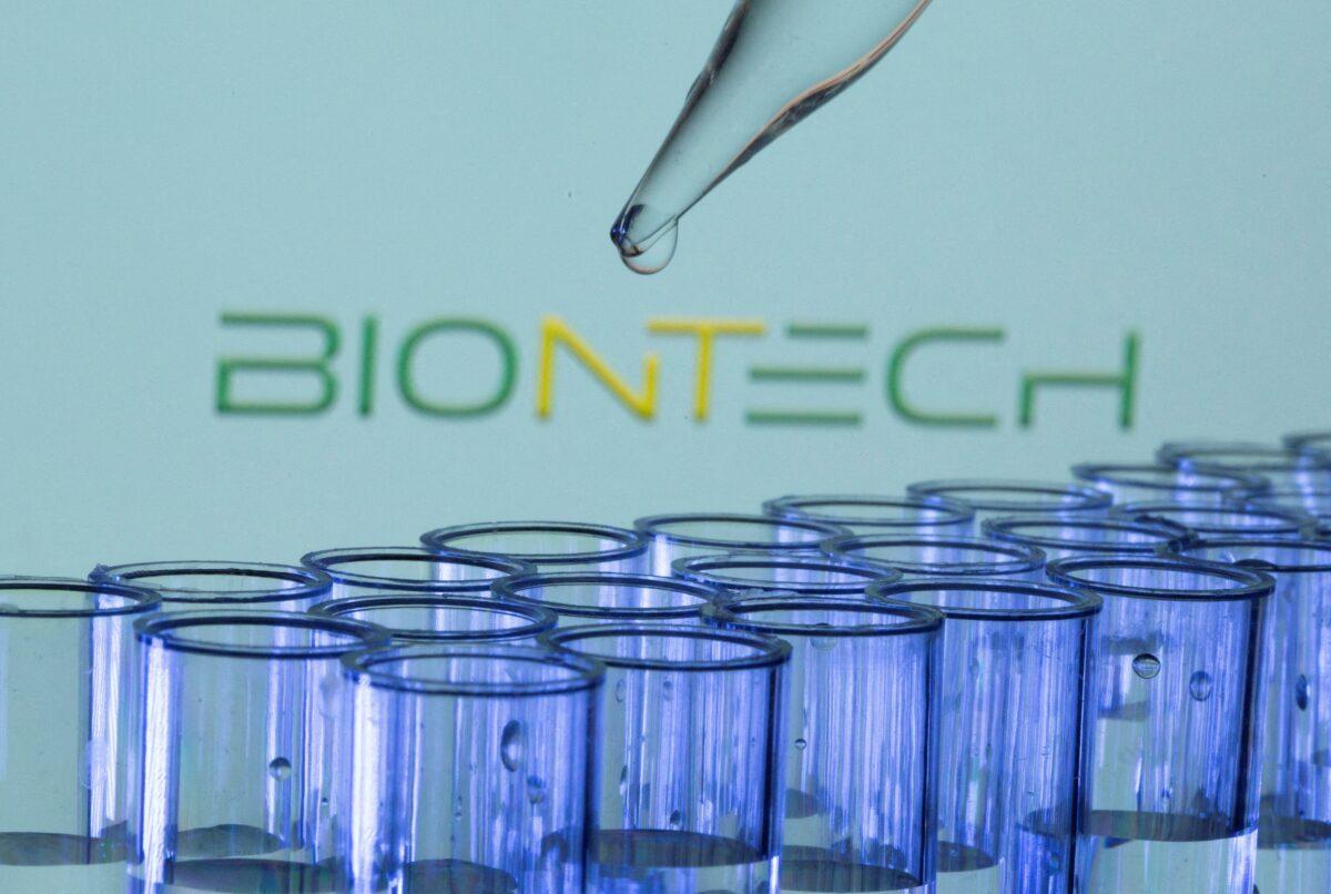 Test tubes are seen in front of a BioNTech logo in a May 21, 2021 illustration image. (Dado Ruvic/Reuters)