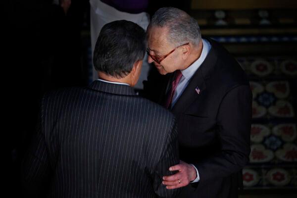 Sen. Joe Manchin (D-W.Va.) (L) talks with Senate Majority Leader Charles Schumer (D-N.Y.) before the ceremony in the Eisenhower Executive Office Building in Washington, D.C., on March 15, 2022. (Chip Somodevilla/Getty Images)