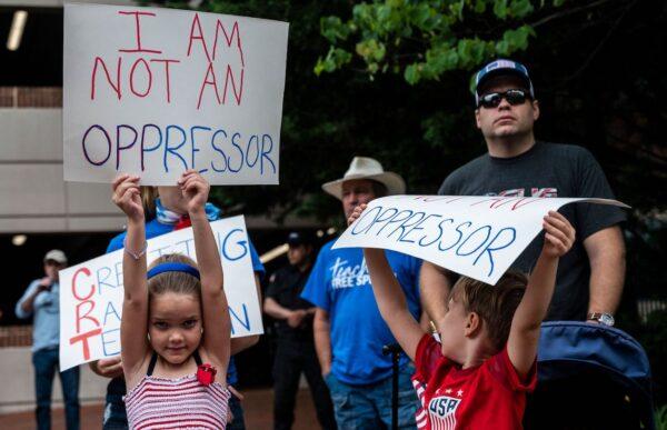 People hold up signs during a rally against critical race theory being taught in schools at the Loudoun County Government center in Leesburg, Virginia, on June 12, 2021. (Andrew Caballero-Reynolds/AFP via Getty Images)
