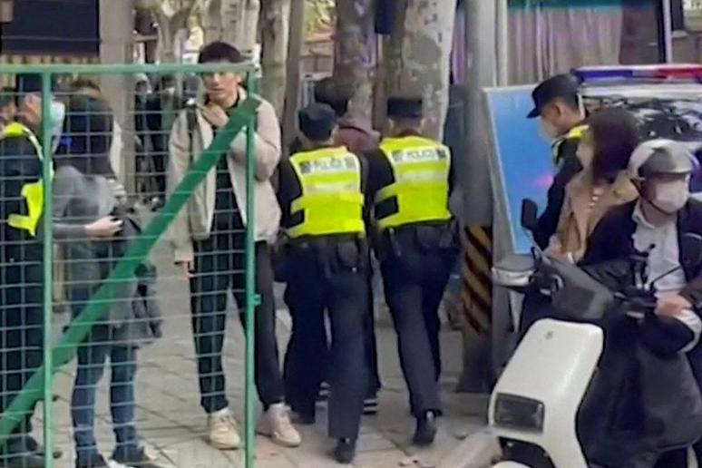 This frame grab from AFPTV video footage shows police detaining a person on Wulumuqi Street, named for Urumqi in Mandarin, in Shanghai on Nov. 28, 2022, where protesters gathered over the weekend to protest against China's Covid-19 restrictions following a deadly fire in Urumqi, the capital of the Xinjiang region. (Matthew WALSH / AFPTV/AFP) (MATTHEW WALSH/AFPTV/AFP via Getty Images)