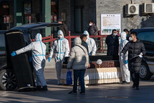 Workers in protective gear handle a coffin at Dongjiao Funeral Parlor, reportedly designated to handle COVID-19 fatalities, in Beijing on Dec. 19, 2022. (Bloomberg via Getty Images)