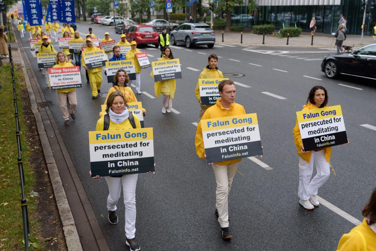 Falun Dafa adherents carry banners raising awareness about the persecution of fellow practitioners in China, during a march through the center of Warsaw, Poland, on Sept. 9, 2022. (Mihut Savu/The Epoch Times)