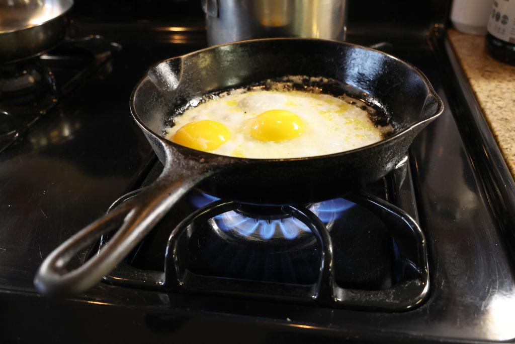 The photo shows eggs being cooked in a cast iron pan over flames on a natural gas-burning stove in Chicago, Illinois, U.S., on Jan. 12, 2023. (Scott Olson/Getty Images)