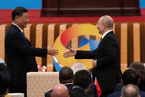 Chinese leader Xi Jinping (L) shakes hands with Russian President Vladimir Putin during the opening ceremony of the third Belt and Road Initiative summit at the Great Hall of the People in Beijing on Oct. 18, 2023. (Pedro Pardo/AFP via Getty Images)