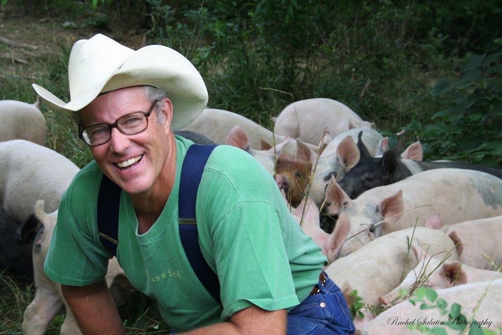 Joel Salatin pictured with his pigs on Polyface Farm, a regenerative farm in Virginia. (Courtesy of Polyface Farm)
