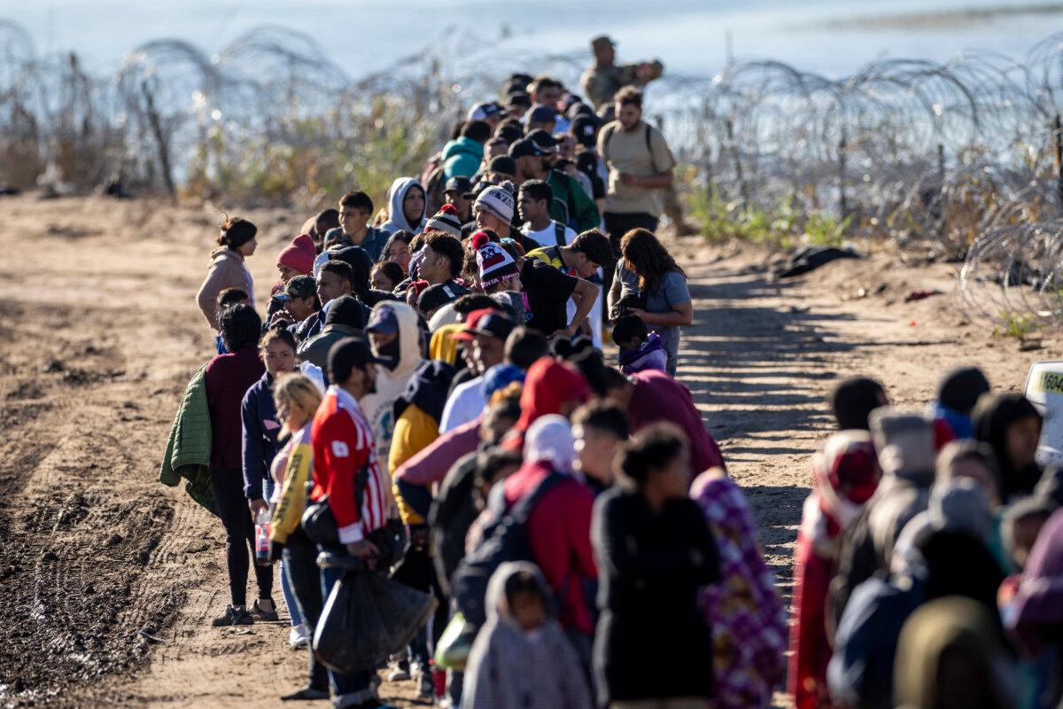 A group of more than 1,000 illegal immigrants wait in line near a U.S. Border Patrol field processing center after crossing the Rio Grande from Mexico in Eagle Pass, Texas, on Dec. 18, 2023. (John Moore/Getty Images)