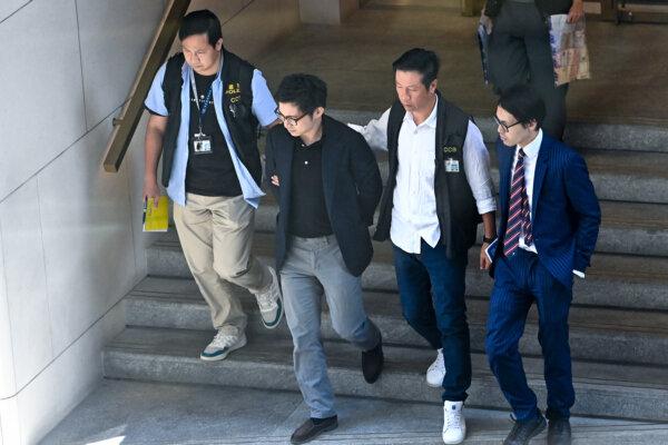 On Sept. 18, 2023, Joseph Lam Chok was escorted by the police to his office at the Entertainment Building in Central for evidence collection. (Sung Pi-lung/The Epoch Times)