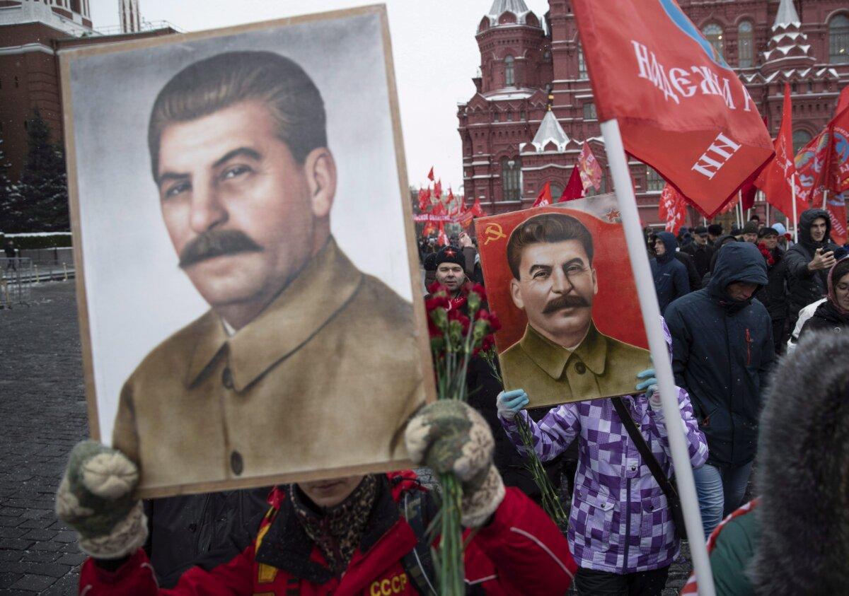Communist supporters hold portraits of Soviet leader Josef Stalin, as they line up to lay flowers at his grave to mark the 139th anniversary of his birth, in Moscow's Red Square, on Dec. 21, 2018. (Pavel Golovkin/AP Photo)