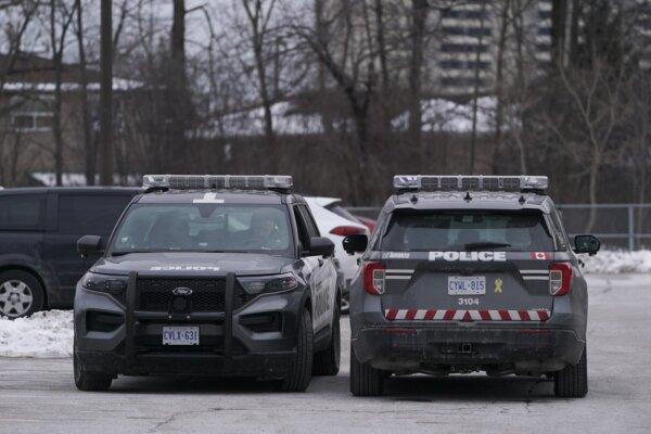 Toronto police vehicles are pictured on Driftwood Avenue in Toronto, on Feb. 18, 2024. (The Canadian Press/Arlyn McAdorey)