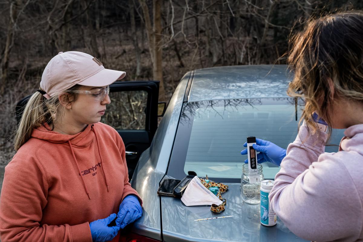 Olivia Holley and Taylor Gulish test the pH and the total dissolved solids of the water from Leslie Run Creek in East Palestine, Ohio, on Feb. 25, 2023. (Michael Swensen/Getty Images)
