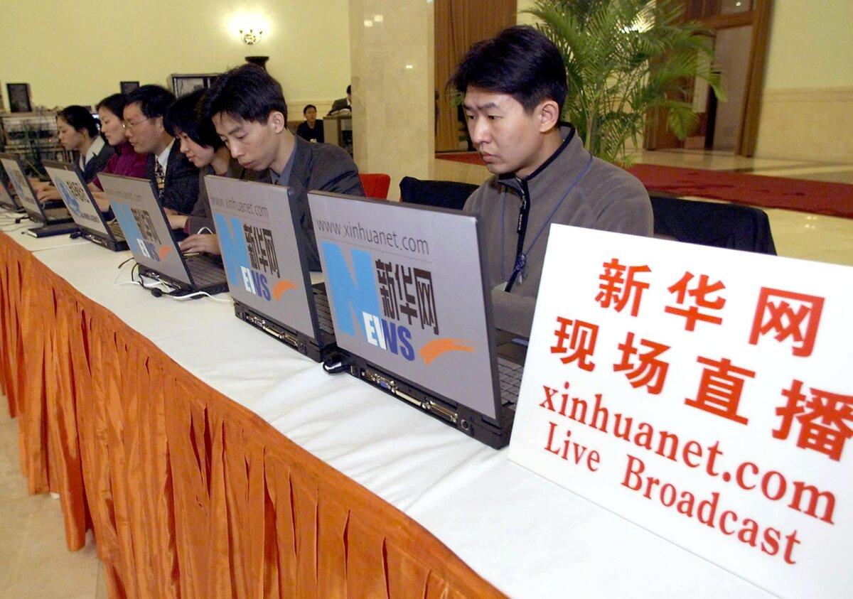 Journalists from China's official news agency Xinhua report directly from the National People's Congress at the Great Hall of the People in Beijing, on March 6, 2001. (Goh Chai Hin /AFP via Getty Images)