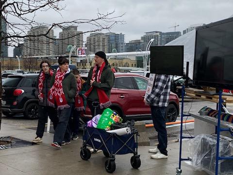 Toronto FC soccer fans look at television screens set up by WHO treaty protesters on their way to BMO Field in Toronto on March 9, 2024. (Courtesy Jody Ledgerwood)
