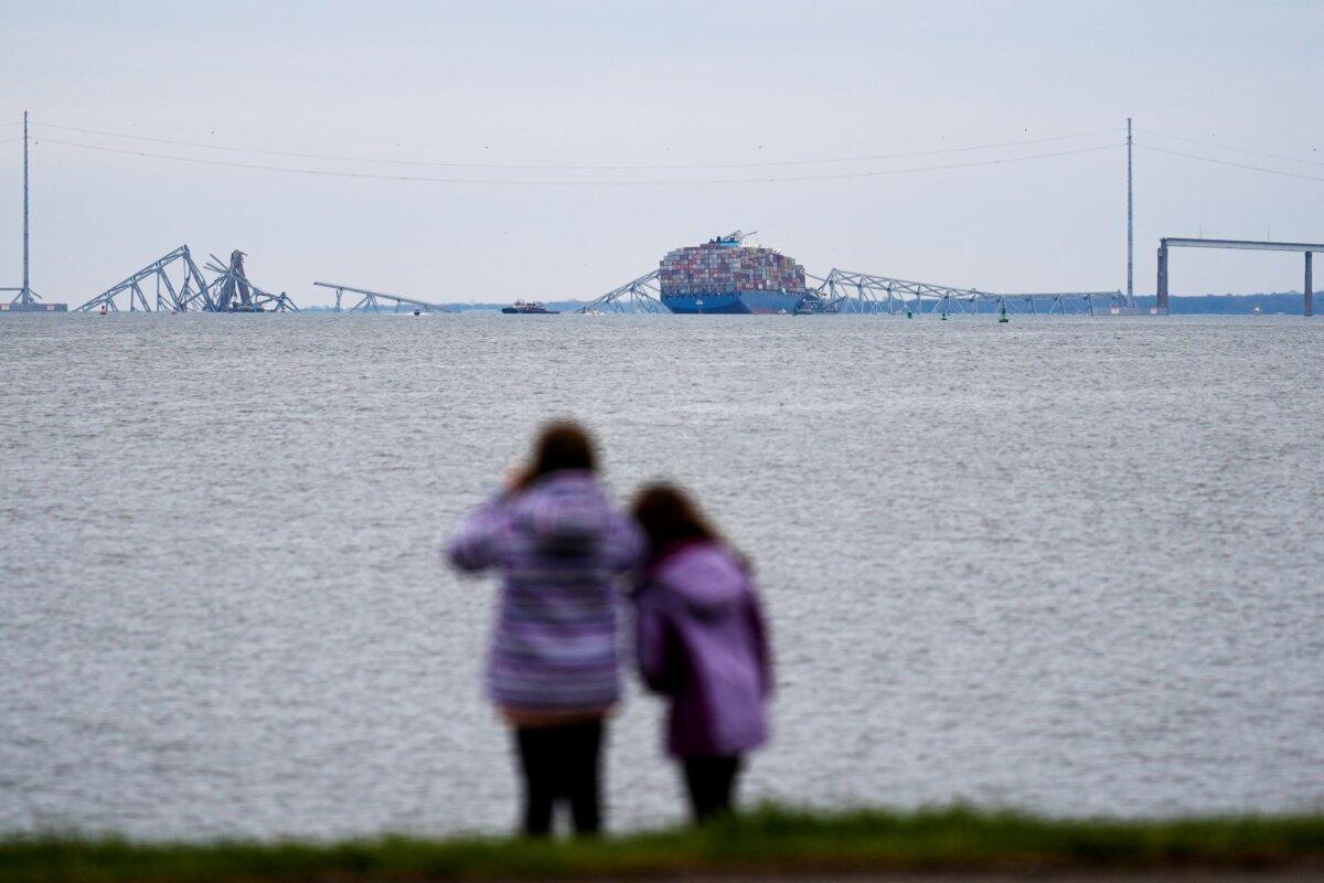 People view from Fort McHenry a container ship as it rests against the wreckage of the Francis Scott Key Bridge, in Baltimore, Md., on March 28, 2024. (Matt Rourke/AP Photo)