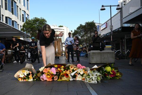Local residents begin to lay flowers at the scene if yesterdays mass stabbing at Bondi Junction, in Sydney, Australia, April 14, 2024. (AAP Image/Dean Lewins)