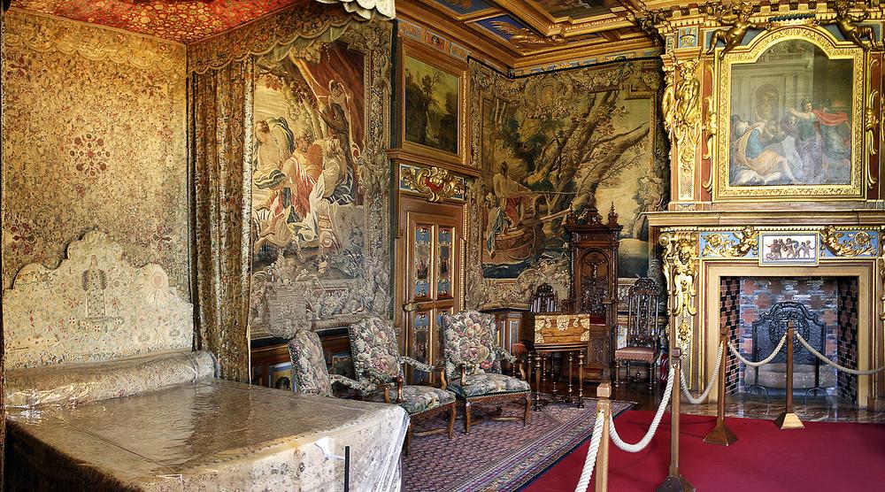 The King's bedchamber of Cheverny Castle encapsulates the timeless elegance and refined taste of French design. Gilded beams traverse the ceiling, imbuing the space with a sense of warmth and character. The walls are adorned with intricate tapestries, draping curtains, and elegant wallpaper. Many of the furnishings, including the bed and fireplace date from the 16th and 17th centuries.  (Pecold/Shutterstock)