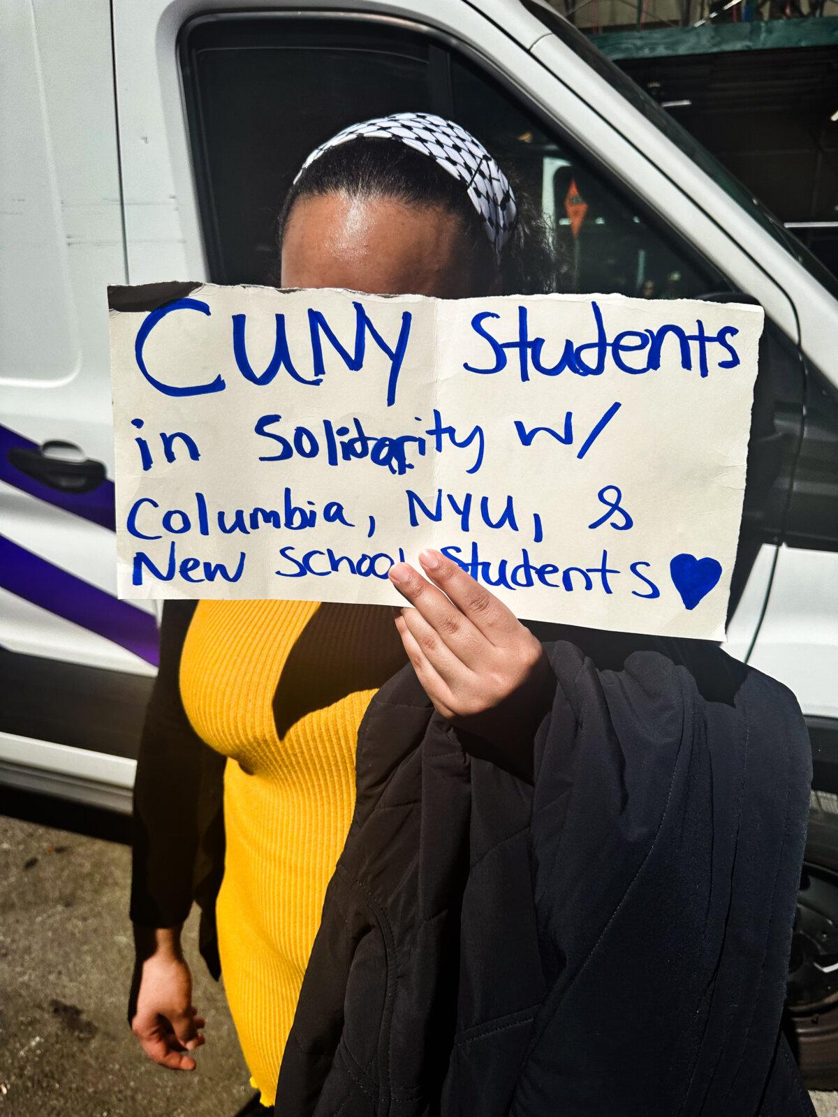 An unidentified CUNY student holds up a sign in support of the April 22, 2024, pro-Palestinian rally. (Juliette Fairley/The Epoch Times)