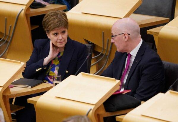 John Swinney (R) talks to Nicola Sturgeon (L) during First Minister's questions at the Scottish Parliament in Holyrood, Edinburgh on Jan. 11, 2024. (PA Wire)