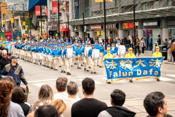 Toronto resides watch as Falun Gong adherents paraded across the city's downtown area on May 11, 2024 to celebrate the 32nd World Falun Dafa Day. (Evan Ning/The Epoch Times)