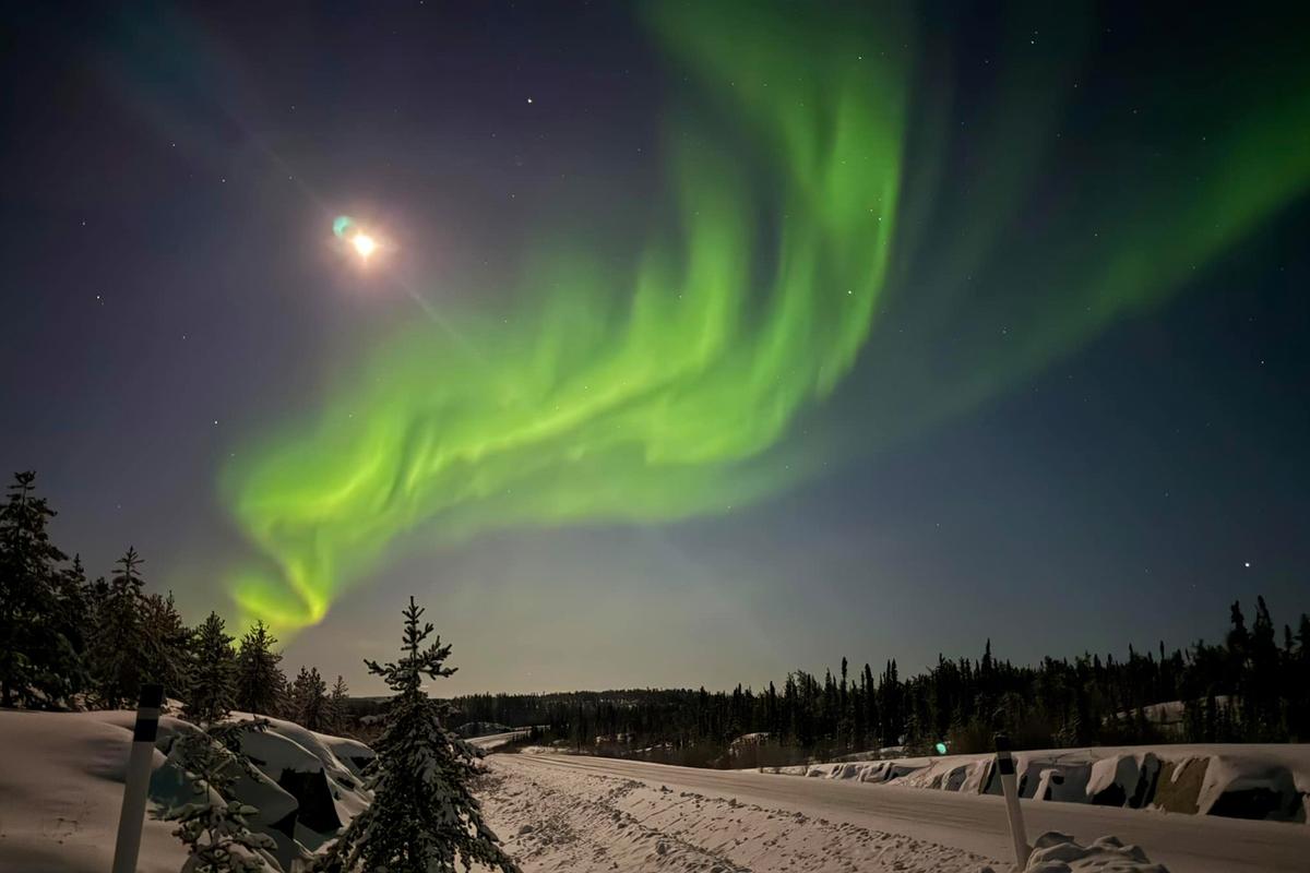An aurora competes with the gibbous moon in mid-December near Yellowknife. (Courtesy of Joe Buffalo Child)