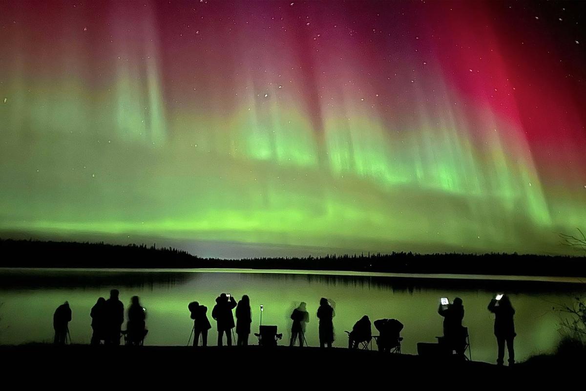 A red and yellow aurora reflects off Pontoon Lake east of Yellowknife in October 2024, during strong geomagnetic storms that occurred last fall. (Courtesy of Joe Buffalo Child)