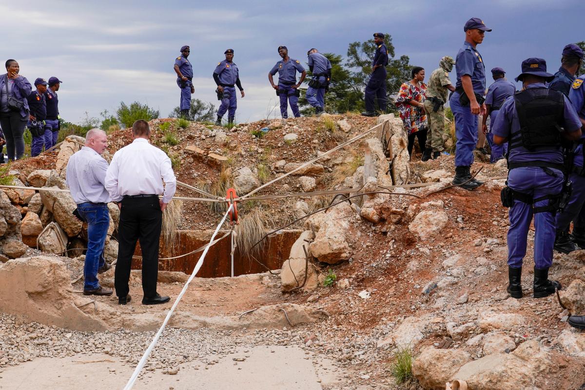 Police officers and private security personnel stand by the opening of a reformed gold mineshaft where illegal miners are trapped in Stilfontein, South Africa, on Nov.15, 2024. (Denis Farrell/AP Photo)