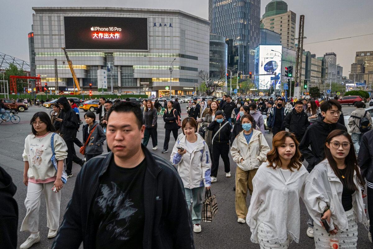 People cross at a traffic light in Beijing on April 8, 2025. (Kevin Frayer/Getty Images)
