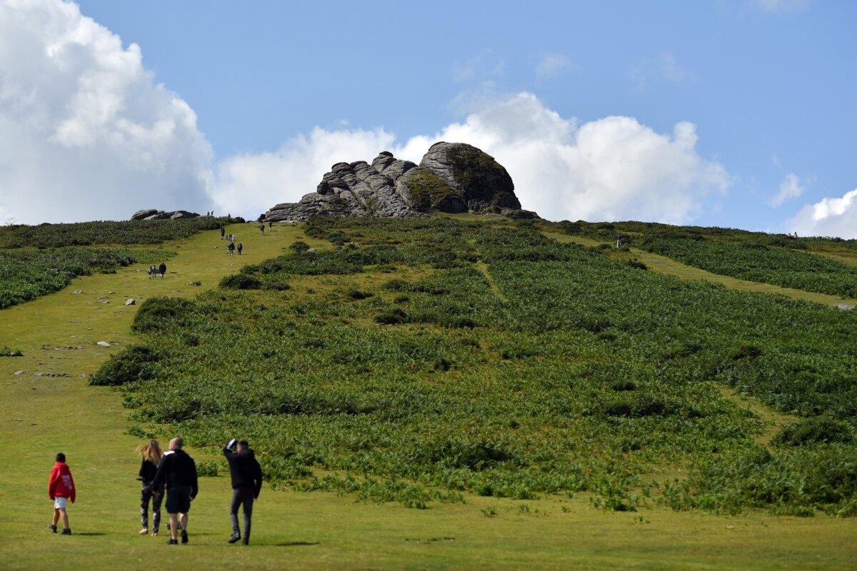 People walk up to Haytor Rocks in Dartmoor National Park, Devon, England, on Aug. 12, 2019. (Ben Stansall/AFP via Getty Images)
