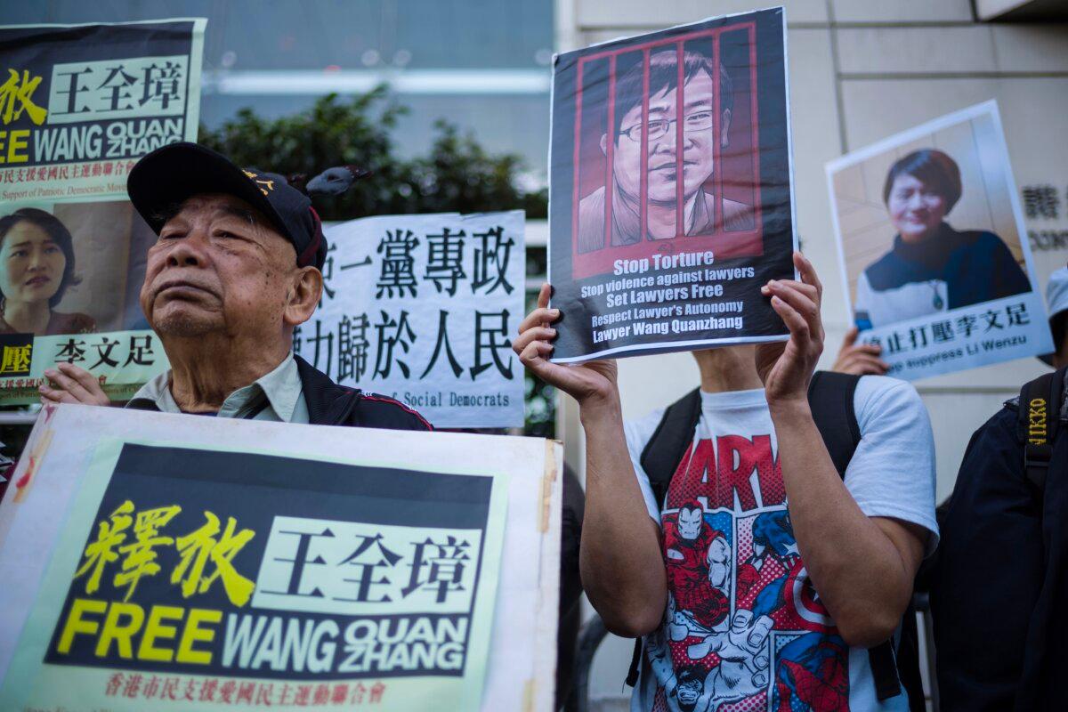 Activists hold placards of detained Chinese human rights lawyer Wang Quanzhang and his wife Li Wenzhu (R) at a rally outside the Chinese Liaison Office in Hong Kong on Dec. 26, 2018. (Anthony Wallace/AFP via Getty Images)