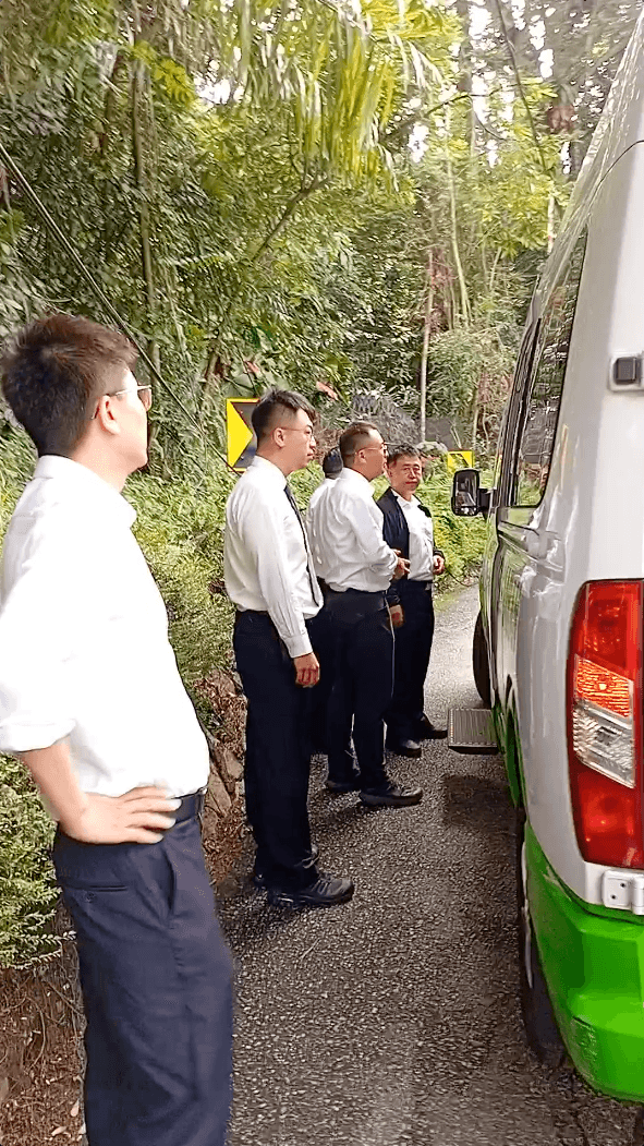 Individuals caught on camera boarding a tour bus after seizing display boards from a Falun Gong booth in Kuala Lumpur, Malaysia, on Aug. 15, 2025. (Screenshot by The Epoch Times)
