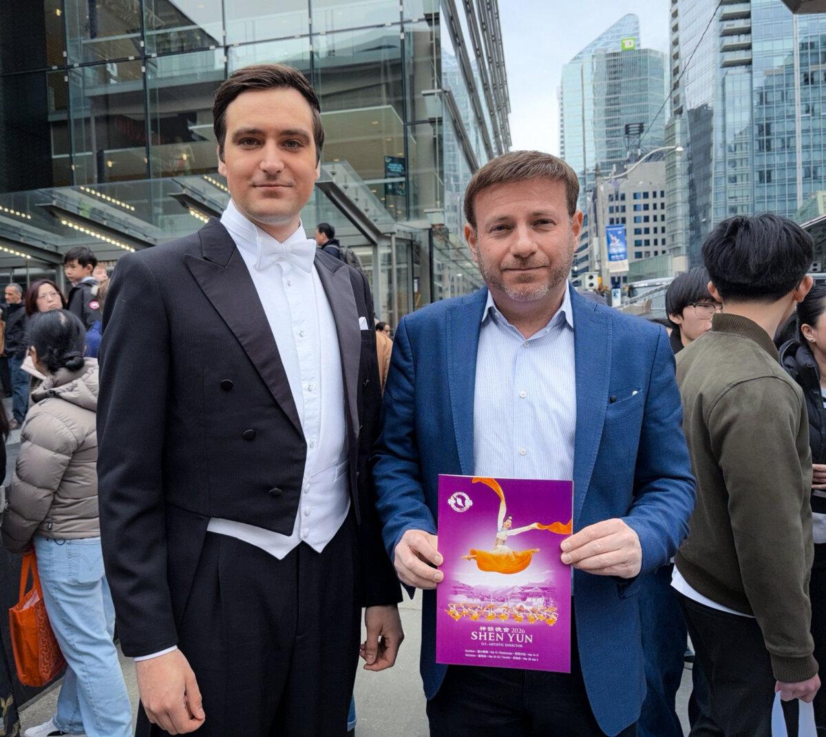 Conservative MP Roman Baber holds a Shen Yun program book while standing with a show host outside the Four Seasons Centre for the Performing Arts in Toronto on March 29, 2026. (The Epoch Times)