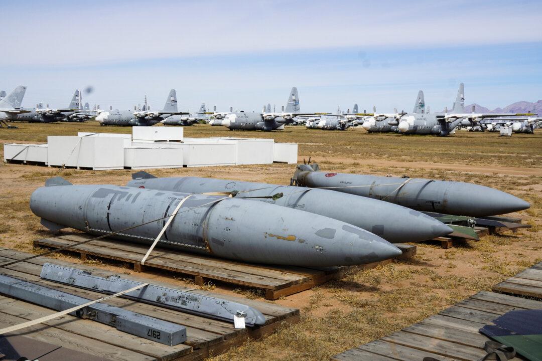(Top) An F-16 jet fighter is dismantled for parts at Davis-Monthan Air Force Base in Tucson, Ariz., on April 21, 2026. (Bottom Left) Reusable fuel tanks from an F-16C jet fighter at Davis-Monthan Air Force Base in Tucson, Ariz., on April 21, 2026. (Bottom Right) An F-16 jet engine ready for delivery at the 309th Aerospace Maintenance and Regeneration Group in Tucson, Ariz., on April 21, 2026. (Allan Stein/The Epoch Times)