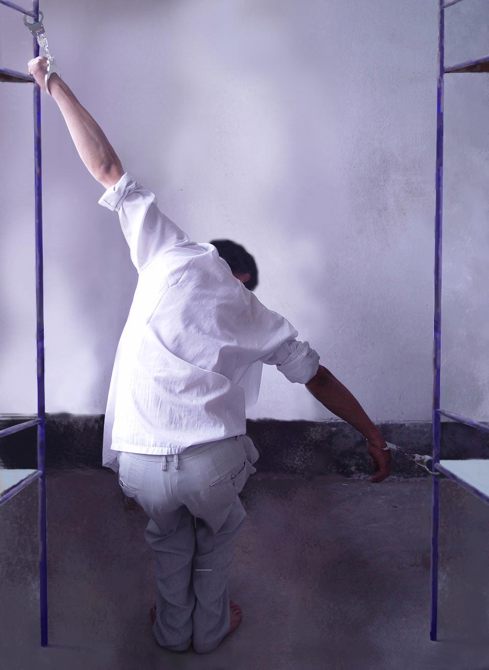 Cuffing to a bed: A reenactment of a torture method employed by the CCP to coerce Falun Gong adherents to give up their faith. (<a href="https://en.minghui.org/">Minghui.org</a>)