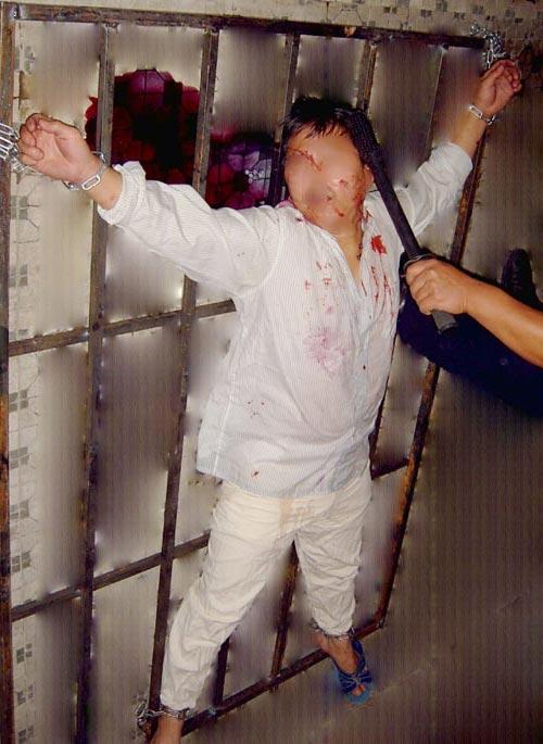 Reenactment of beating a prisoner of faith with an electric baton while he is chained to a metal frame in a “spread-eagle” position. (<a href="https://en.minghui.org/">Minghui.org</a>)