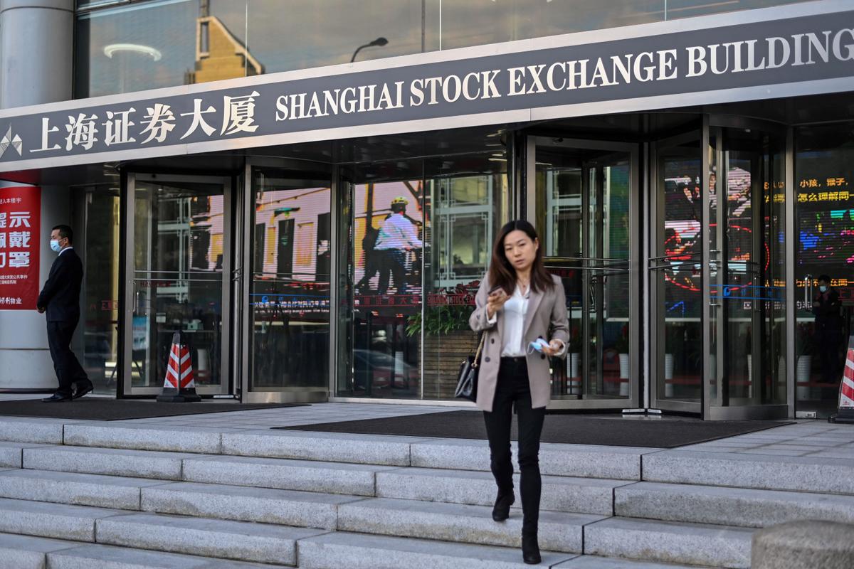 People walk outside the Shanghai Stock Exchange building in Shanghai on Nov. 4, 2020. (Hector Retamal/AFP via Getty Images)