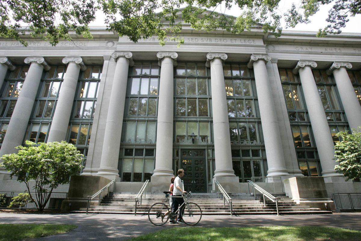 A bicyclist walks by Langdell Hall, the Harvard Law Library, on the campus of Harvard Law School in Cambridge, Mass. (Charles Krupa/AP Photo)