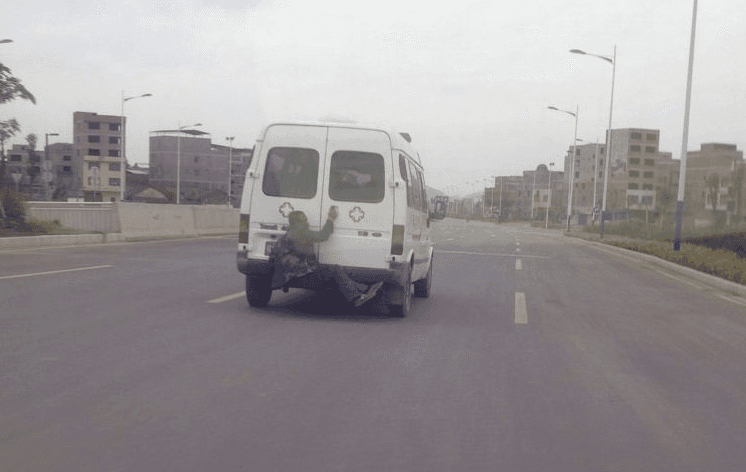 Chinese Man Escapes on Back of Ambulance