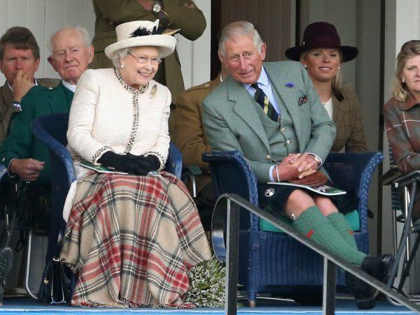 Prince Charles (R) sits with his mother, Queen Elizabeth II, at the Braemar Highland Games in Scotland in September 2014. (Chris Jackson/Getty Images)