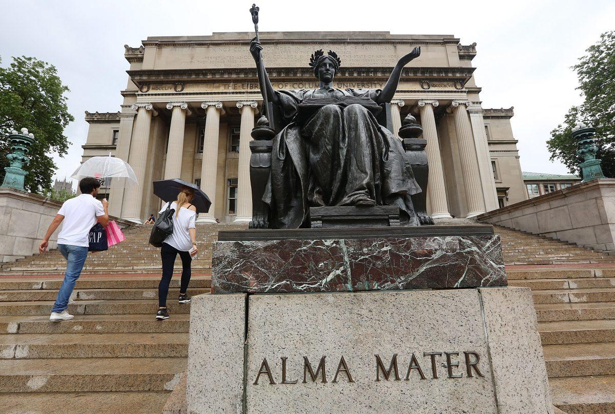 People walk past the Alma Mater statue on the Columbia University campus in New York, on July 1, 2013. (Mario Tama/Getty Images)