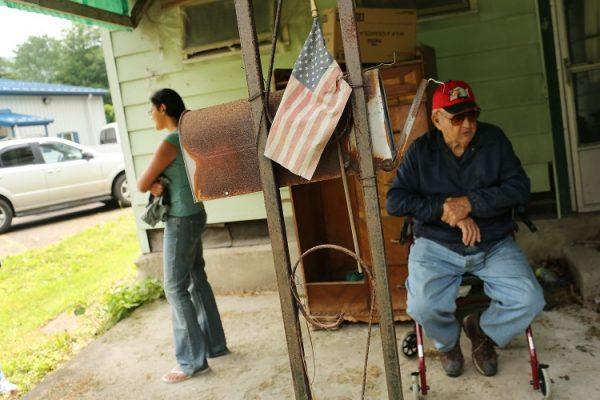 People wait for food from a food bank in June in Deposit, N.Y. Many cities across New York state have seen a decline in residents and jobs since 1980 and before, according to a new report. (Spencer Platt/Getty Images)