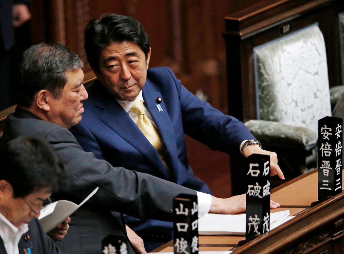 Former Japanese Prime Minister Shinzo Abe (R) talks to Shigeru Ishiba, the then-minister for vitalizing local economy in Japan, during a plenary session at the lower house in Tokyo on July 16, 2015. Ishiba's visit last week to Taiwan along with five other Japanese lawmakers didn't go over well with the Chinese Embassy in Tokyo, which reacted strongly to the visit. (AP Photo/Shuji Kajiyama)
