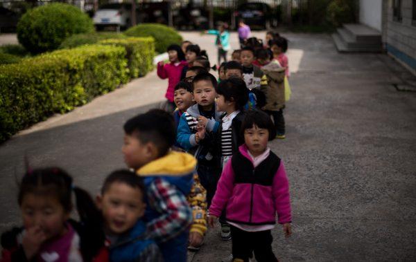 Children playing in the schoolyard of the once-bustling Technical Secondary School in Rudong, Jiangsu province, on April 17, 2015. (JOHANNES EISELE/AFP/Getty Images)