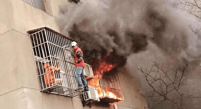 Watch: Chinese Deliveryman Rips Open Metal Grating to Save Woman From Fire