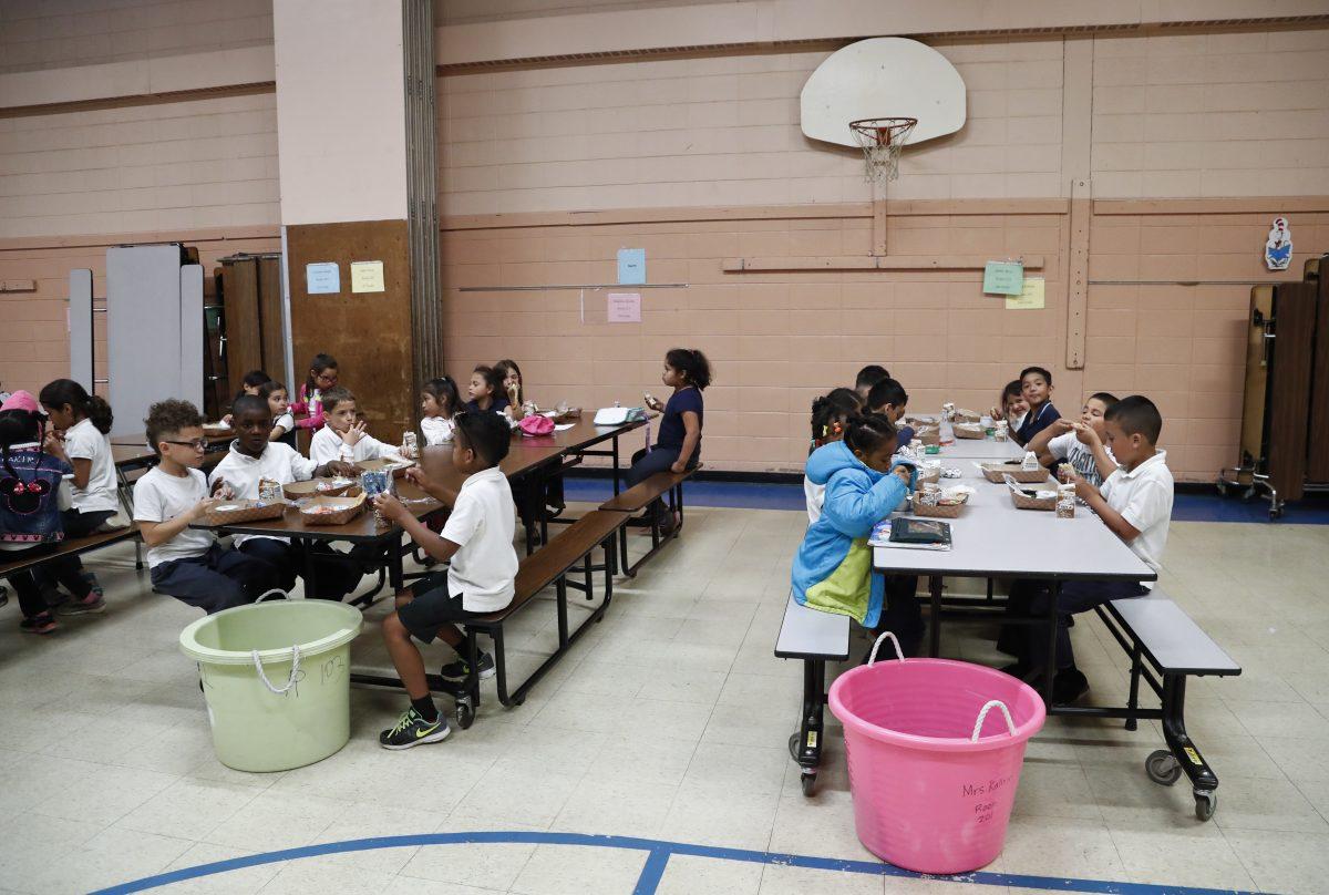 Students eat lunch inside the school's gym at Little Fort Elementary School in Waukegan, Ill., on June 23. (Kamil Krzaczynski/AP Photo)